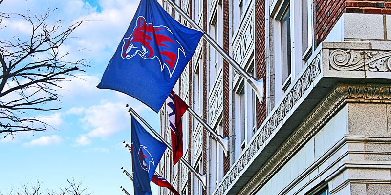 RSU Hillcat flags flying on side of building