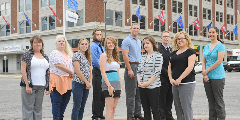 Group of students standing in front of the Bartlesville campus building.
