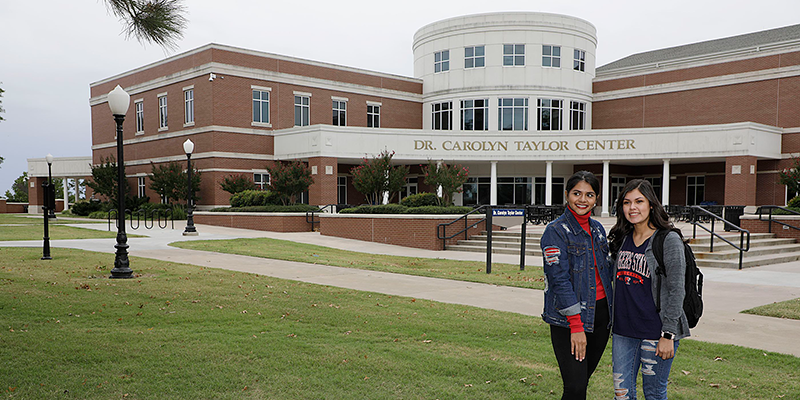 two girls posing in front of building