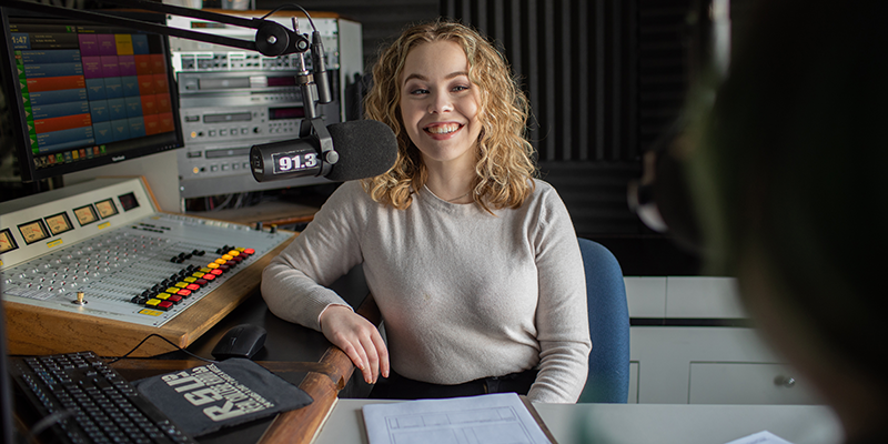 Girl in radio booth smiling