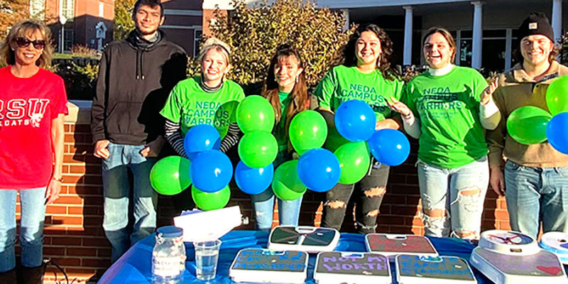 people wearing green shirts holding balloons