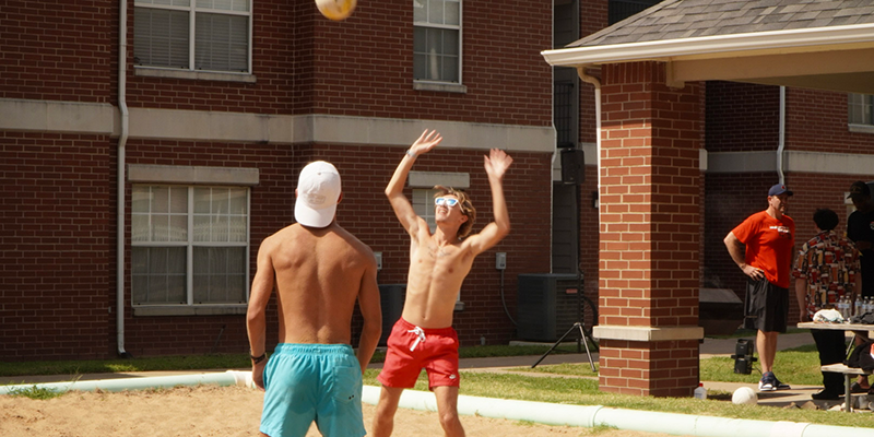 2 male students playing volleyball
