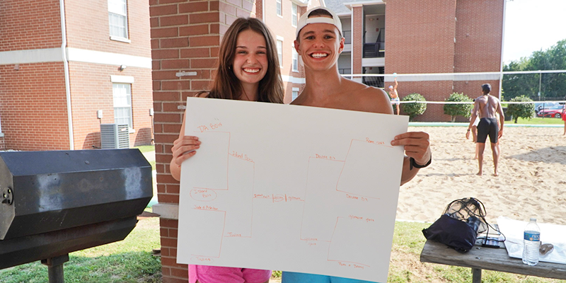 girl and boy holding tournament bracket poster