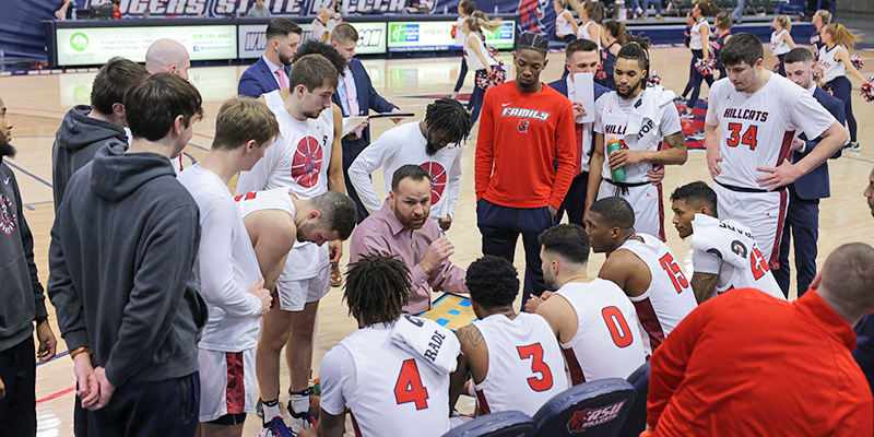 Coach with players huddled around.