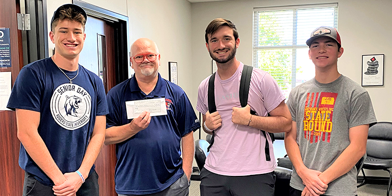 Phi Delta Theta Chapter President Matthew Garrison (from left), Professor Bruce Hartley, fraternity members Ben Brown and Brody White.