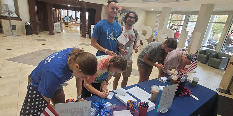 people signing up at a table