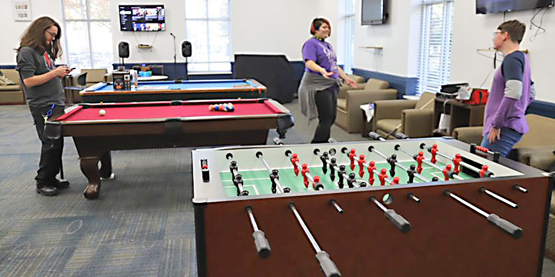 people in a recreation room with game tables