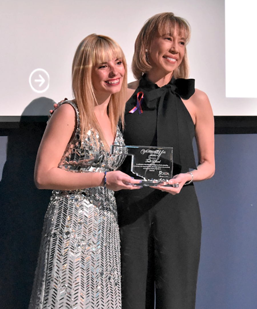 two women posing with award