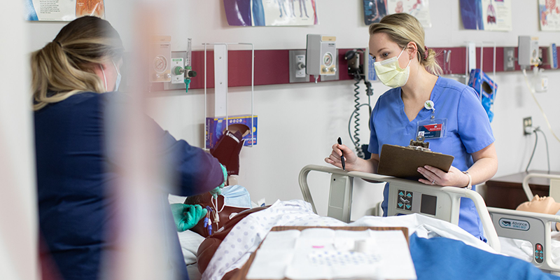 girl standing beside wearing scrubs and mask