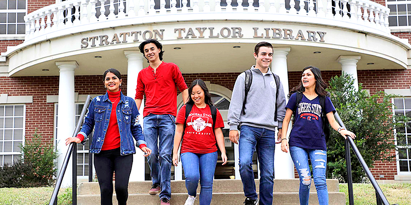 students walking down steps in front of library