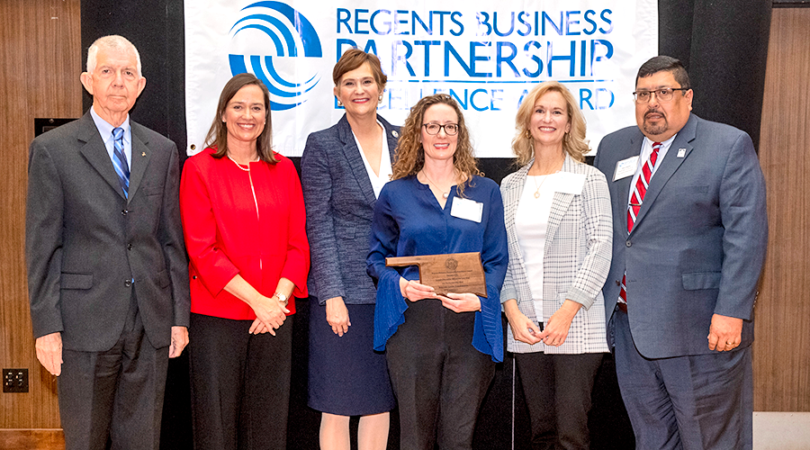 group of people posing for photo with award