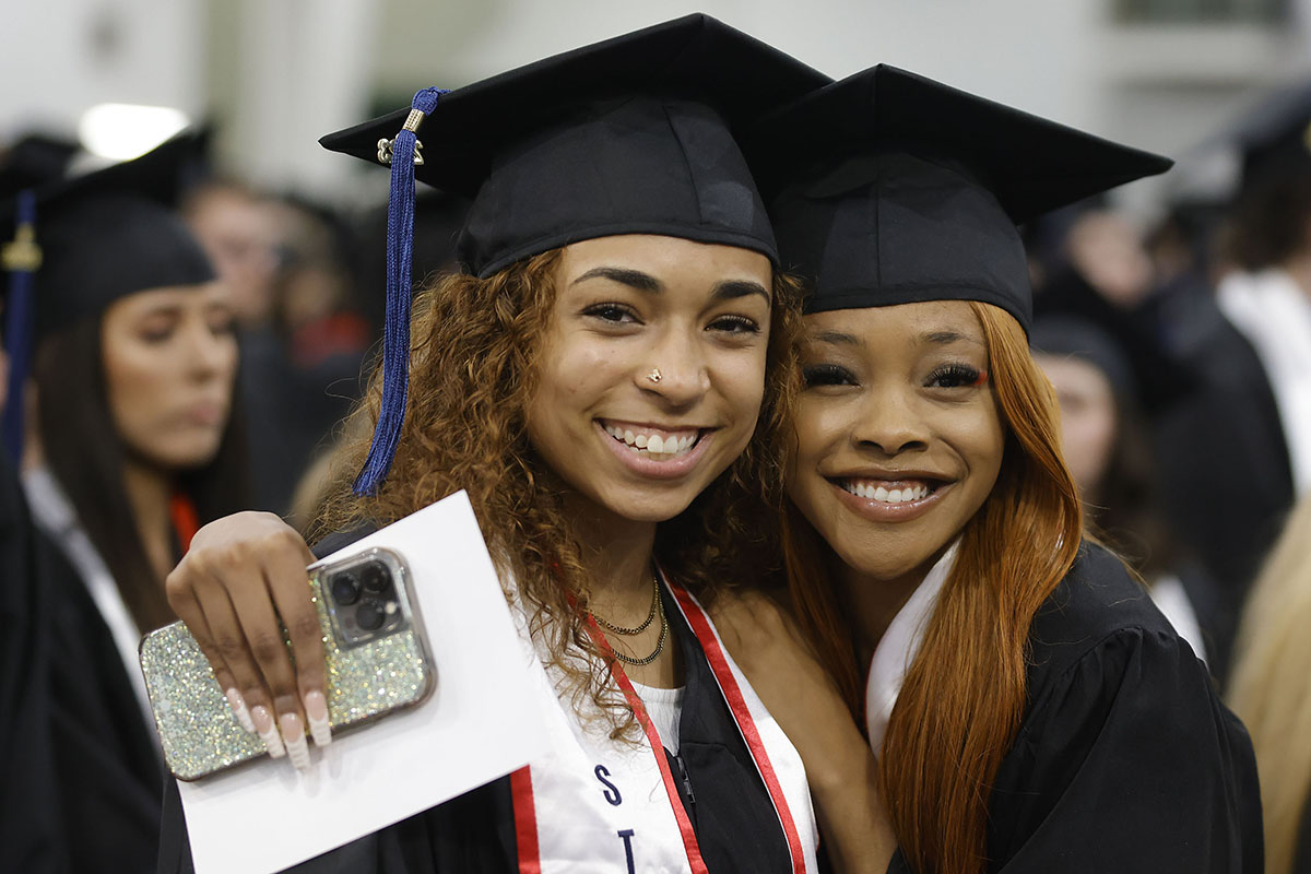 girls hugging and smiling at graduation