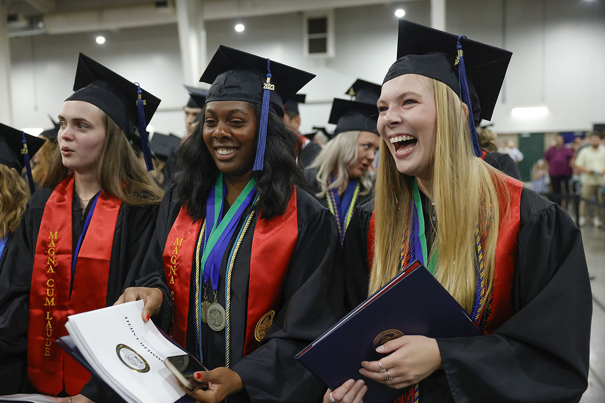 girls wearing graduation regalia lauging