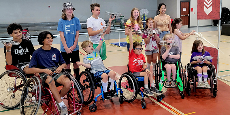 group photo of kids in wheelchairs and volunteers at stem camp