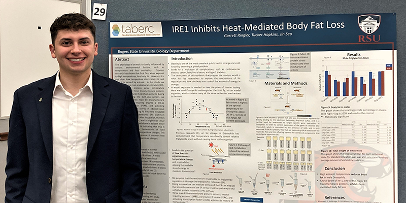 Garrett Ringler standing next to research chart