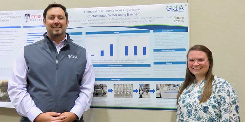 man and woman standing in front of poster presentation