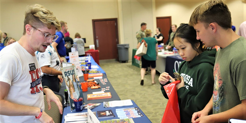 Students vising booths at a college fair