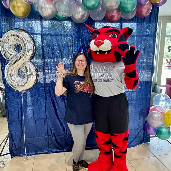 girl posing with cat mascot