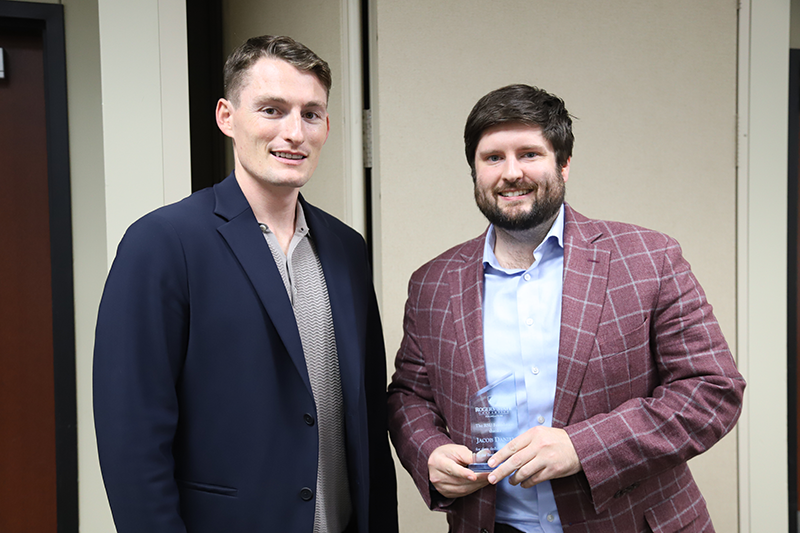 two men shaking hands with award