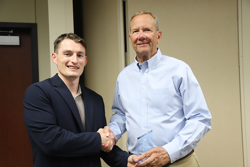 two men shaking hands with award