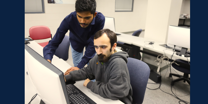 two men looking at computer