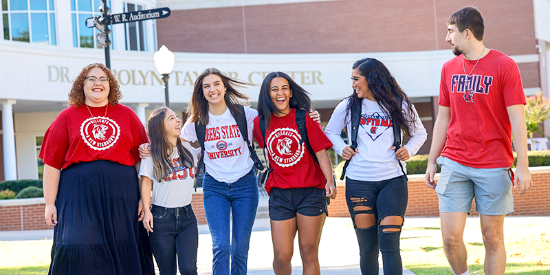 Group of students laughing on college campus