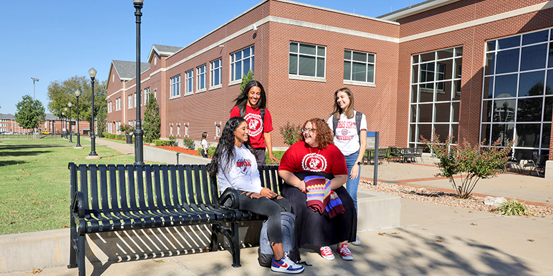 Group of girls sitting on a bench and talking