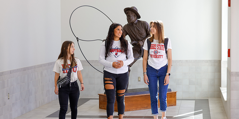 Girls walking in front of Will Rogers statue