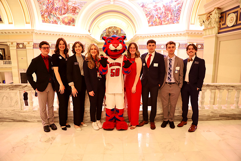 students posing with mascot in capitol rotunda