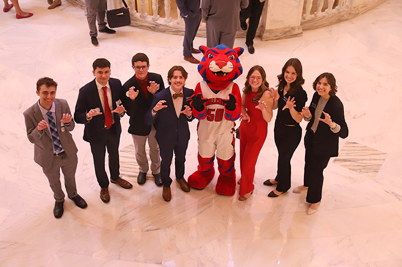 students posing with mascot in capitol rotunda