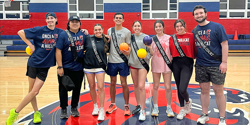 students posing on basketball court