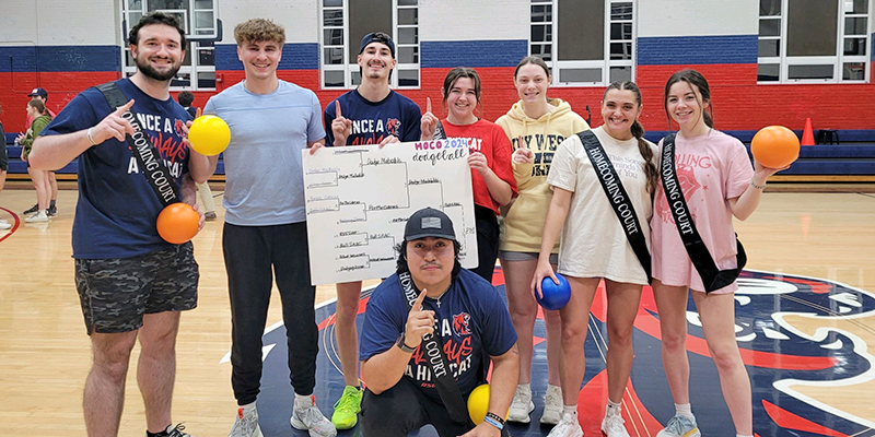 students posing on basketball court