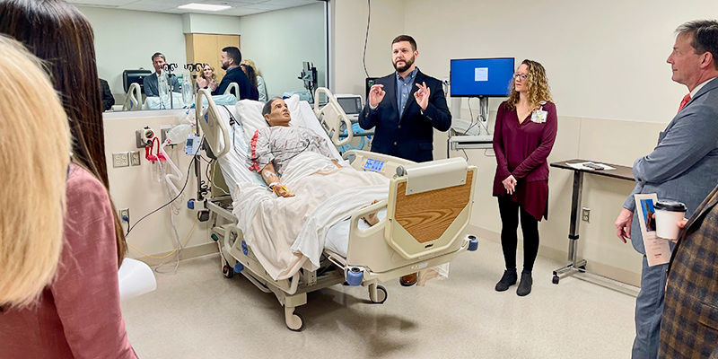 man talking to group in nursing simulation room