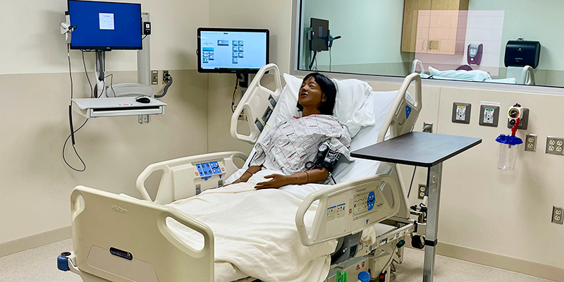 nursing simulation room with a manikin in hospital bed