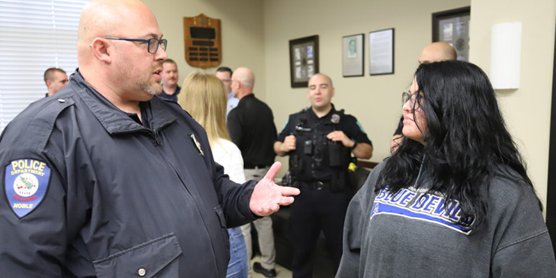 Cop talking with student.