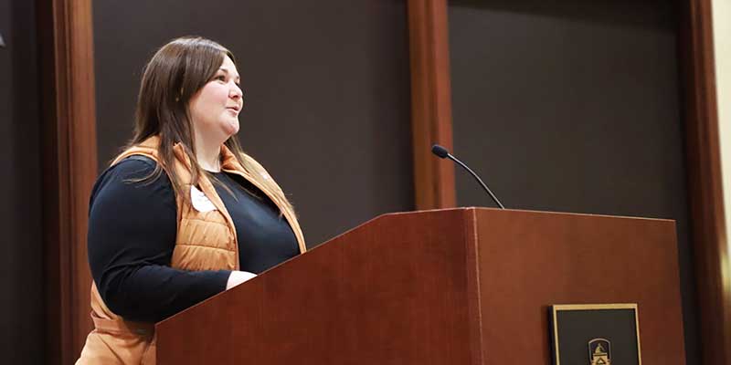 Woman speaking at podium.