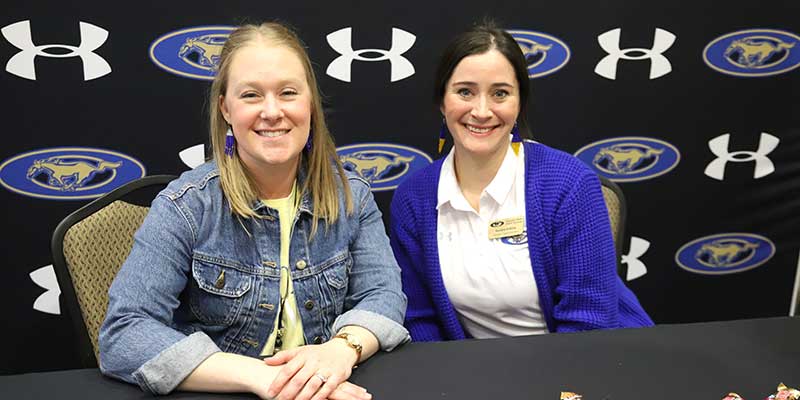 2 girls sitting at table during a career fair