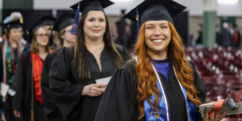 Graduates walking into graduation ceremonies.