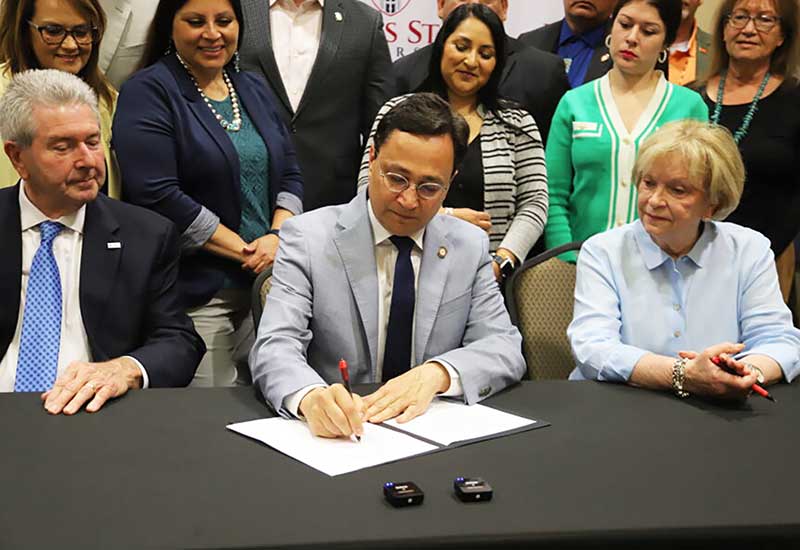 Principal Chief of the Cherokee Nation Chuck Hoskin, Jr. signing papers.