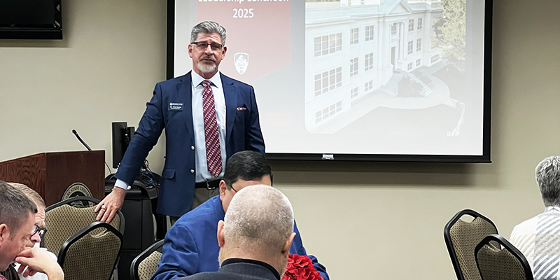 Dr. Mark Rasor stands and speaks to a room full of people