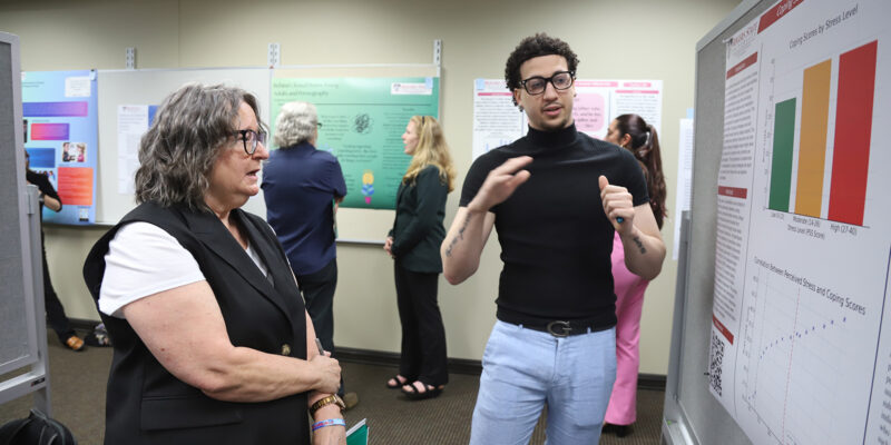 A male student discusses his project with a female professor
