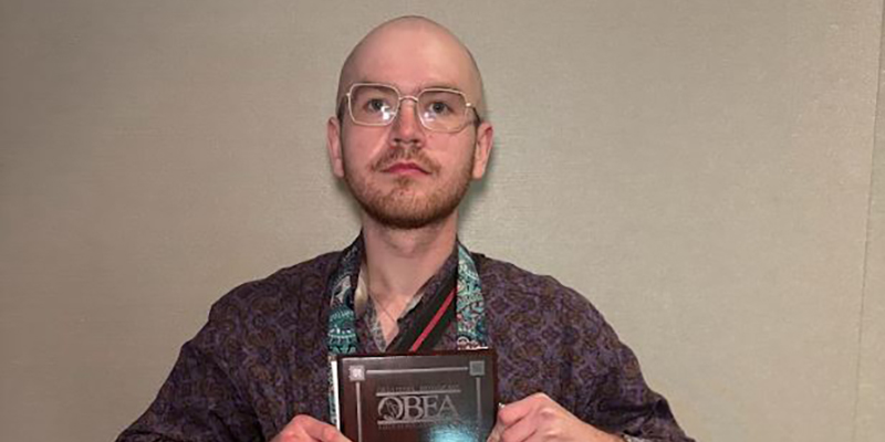 A male student holds an award.