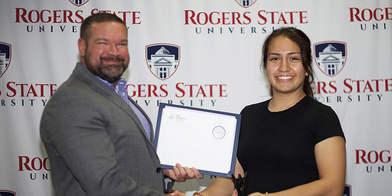 A male professor congratulates a female student
