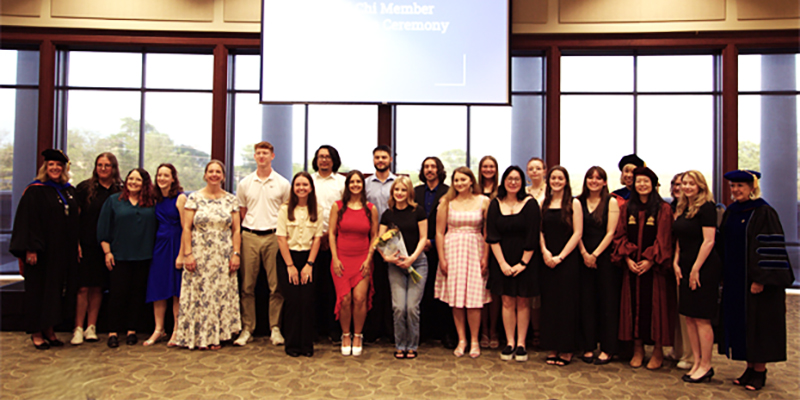 A large group of RSU students, along with professors, pose for a group photo in the DCTC ballroom