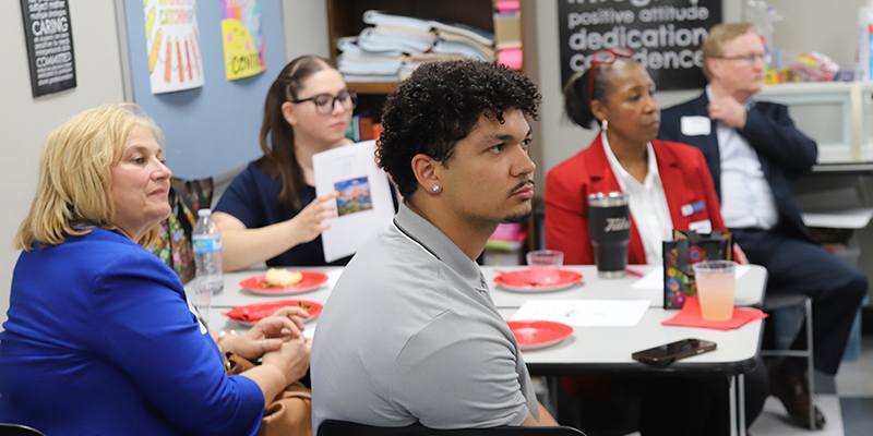 A group of adults listen to a speaker