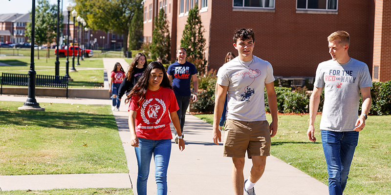 RSU students walk on a sidewalk outside of Baird Hall