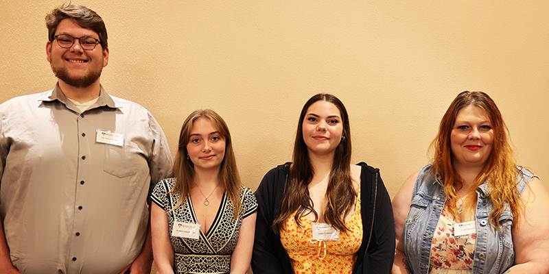 Four smiling students pose for a photo