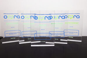 Glass awards with blue and green lettering.