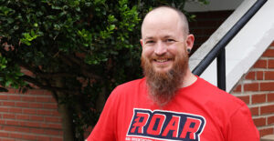 A smiling man standing on stairs.