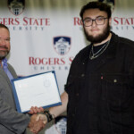 Hawken Grubbs, instructor of technology and justice studies, congratulated students on their outstanding showing in the National Cyber League Competition. A smiling male professor congratulates a student